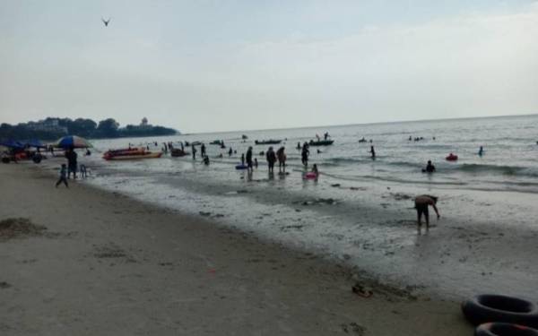 Orang ramai beriadah di Pantai Teluk Kemang, Port Dickson pada Ahad.