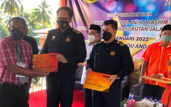 Zailani Hashim (dua dari kiri) menyampaikan Sijil Penyertaan Kursus Pensijilan Pengajar Institut Memandu (SPIM) Zon Timur kepada Mohd Rosdi Amir Mohd Sidek di Akademi Memandu Anda di Melor, Kota Bharu pada Ahad.