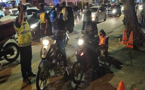 Pegawai penguat kuasa JPJ Pahang membuat pemeriksaan terhadap penunggang motosikal dalam Ops Khas Motosikal sempena Tahun Baharu Cina di Jalan Teluk Sisek, pada malam Ahad.