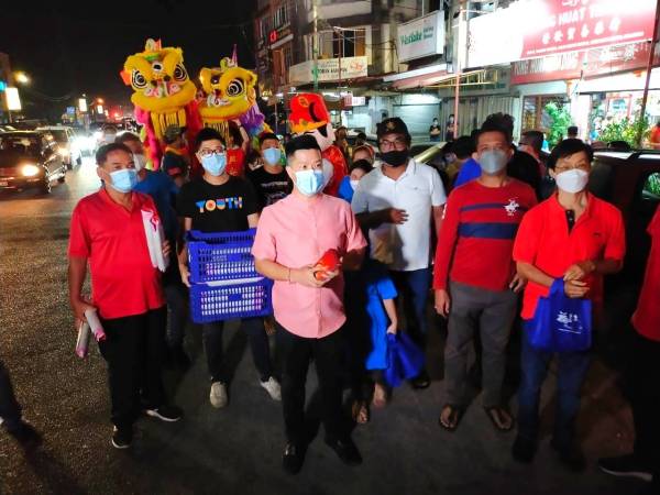 Hock Kuan (tiga dari kiri) bersama pimpinan MCA Kelantan mencipta kelainan apabila berjalan sejauh 6 km mengagihkan angpau dan limau kepada orang ramai serta dimeriahkan dengan persembahan tarian singa.
