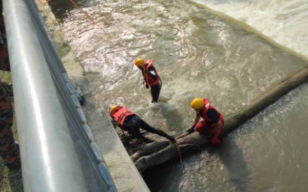 Anggota bomba berusaha membawa naik mayat mangsa yang ditemukan terapung di Ipoh. Foto: ihsan Bomba Perak