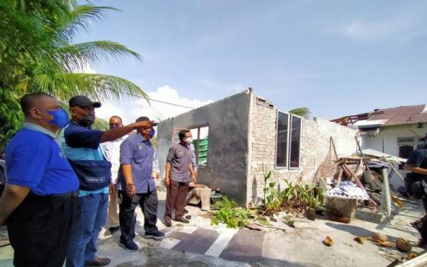 Saarani (kiri) melihat keadaan sebuah rumah penduduk yang rosak teruk akibat ribut di Kampung Desa Sri Chepor, Klebang di sini pada Isnin.