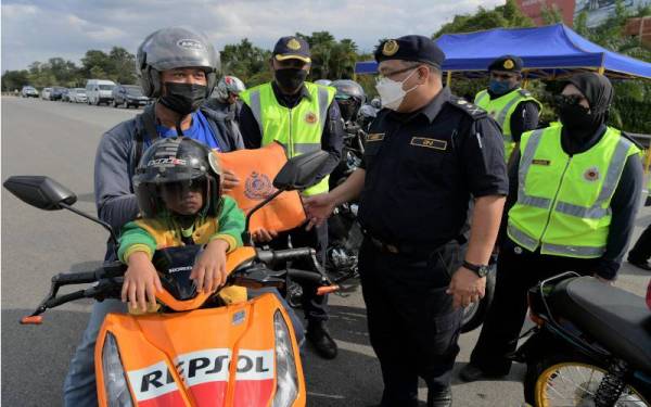 Azmil menyampaikan cenderahati kepada para pengguna jalan raya ketika meninjau Operasi Khas Sempena Sambutan Tahun Baharu Cina 2022 di Plaza Tol Skudai, pada Isnin. -- Foto Bernama 