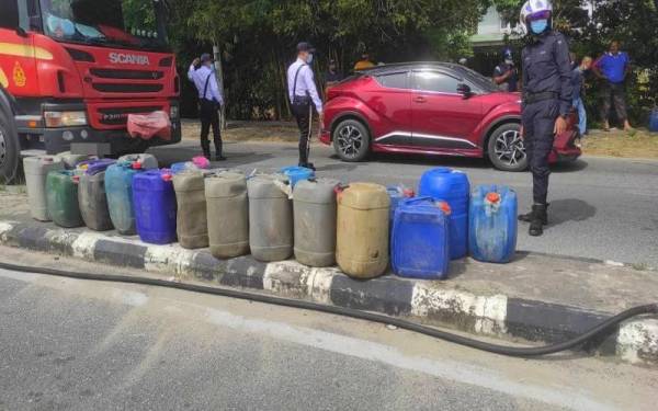 Sebahagian tong berisi minyak petrol yang ditemui dalam sebuah kereta terbabas di pembahagi jalan di hadapan sebuah pasar raya di Tendong, Pasir Mas Isnin.