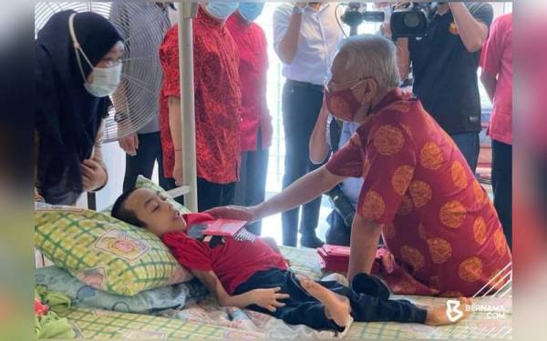 Ismail Sabri menyerahkan 'ang pao' sempena sambutan Tahun Baharu Cina kepada salah seorang penghuni Pusat Jagaan Persatuan Kebajikan Kanak-kanak Istimewa Insan di Kuala Lumpur pada Selasa. - Foto Bernama