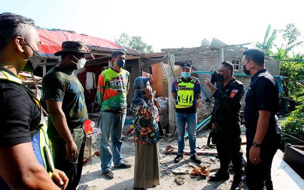 Mazian (dua dari kanan) berbual dengan mangsa ribut, Azmi (tengah) ketika mengadakan operasi membantu dan membersihkan persekitaran yang terjejas akibat ribut di Taman Desa Sri Chepor pada Rabu. - Foto Bernama