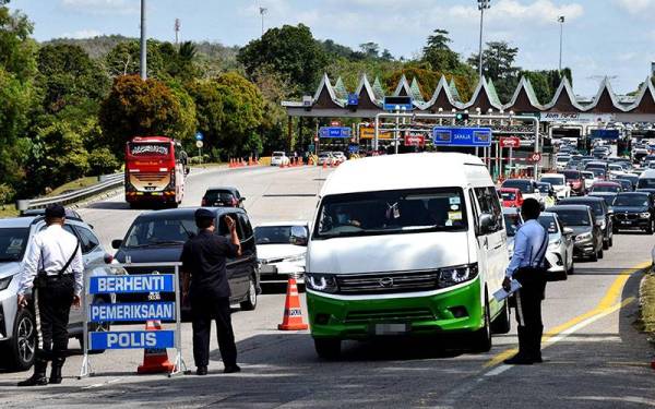 Anggota polis trafik memeriksa kenderaan yang memasuki Melaka di Tol Ayer Keroh pada Rabu. - Foto Bernama