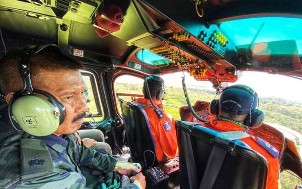 Mohd Sail bersama juruterbang, Superintendan Hasli Hassan dan pembantu juruterbang, Asisten Superintendan M Vithayatharan Nair membuat tinjauan udara di sempadan Malaysia-Thailand di Bukit Kayu Hitam.