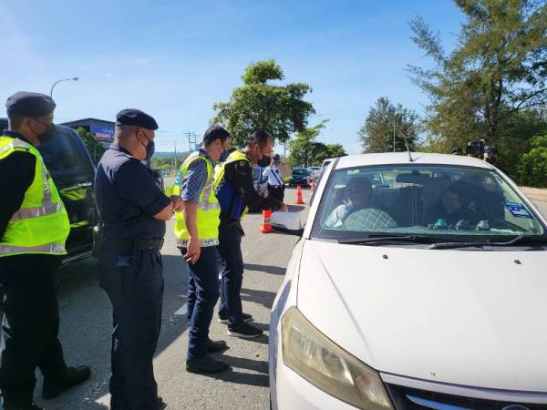 Jauteh membuat pemeriksaan di sekatan jalan sempena Op Selamat 17 Sempena Tahun Baru Cina 2022 di Jalan Meruntum, Putatan.