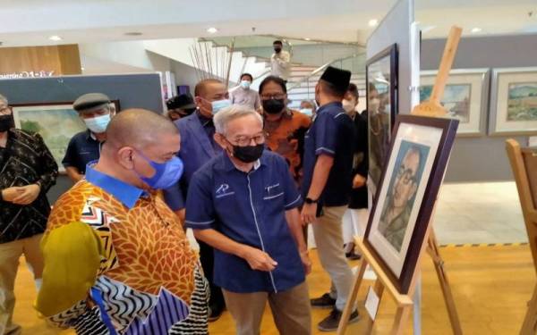 Saarani (kiri) menyaksikan karya seni yang dipamerkan pada Pameran Seni Visual Perak Man Art Trail dan Pameran Solo Salleh Ismail di lobi Hotel Casuarina @ Meru, di sini pada Sabtu.
