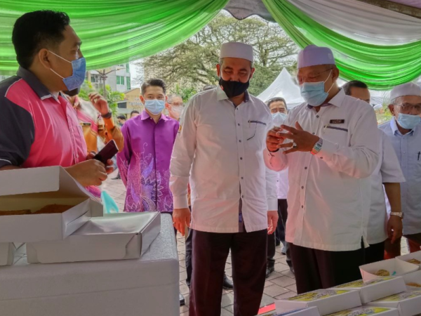 Ahmad (kanan) melawat gerai-gerai jualan semasa merasmikan KALA Sentral di Dataran Muhammadi, Kota Bharu pada Ahad.