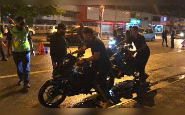 Dua penunggang menolak motosikal masing-masing menuju ke Akademik JPJ Wilayah Timur Kota Bharu untuk diperiksa oleh pihak berkuasa pada Operasi Bersepadu Penguatkuasaan Khas Motosikal pada Ahad.