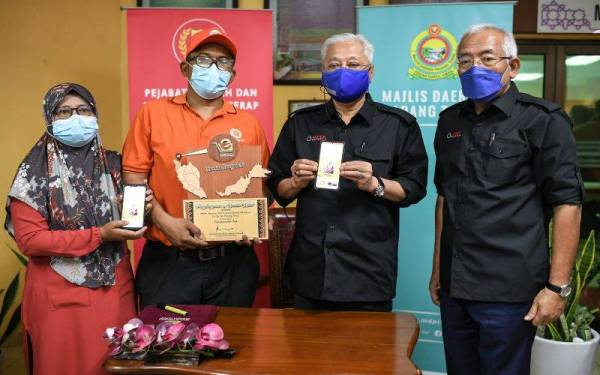  Ismail Sabri (dua dari kanan) bergambar bersama pemilik aplikasi e-Desa, Saiful Zaharin Zakariya, 45, (dua, kiri) dan isteri, Fadhilah Azmi, 45, (kiri) selepas mempengerusikan Mesyuarat Majlis Pihak Berkuasa Pelaksanaan Koridor Utara Ke-28 di Pejabat Daerah dan Tanah Padang Terap pada Isnin. -fotoBernama