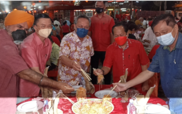 Hasni (tengah) bersama tetamu lain menggaul yee sang ketika Majlis Jamuan Muhibah Tahun Baharu Cina di Pontian Besar pada malam Isnin.