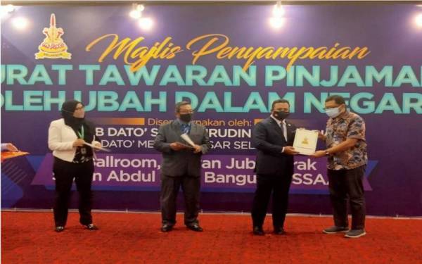 Amirudin (dua dari kanan) menyampaikan Surat Tawaran Pinjaman Boleh Ubah Dalam Negara kepada salah seorang penerima, pada Selasa.