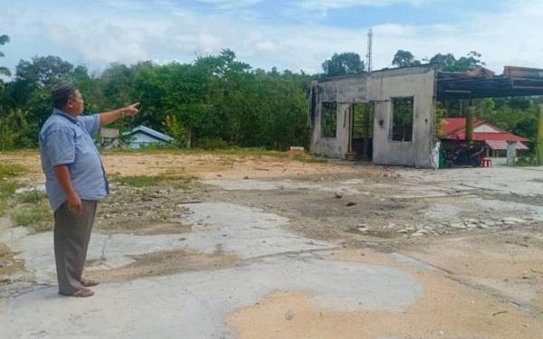 Shuib menunjukkan rumah pusaka yang tidak mampu dibaik pulih setelah hangus dalam tragedi kebakaran 5 Ogos lalu.