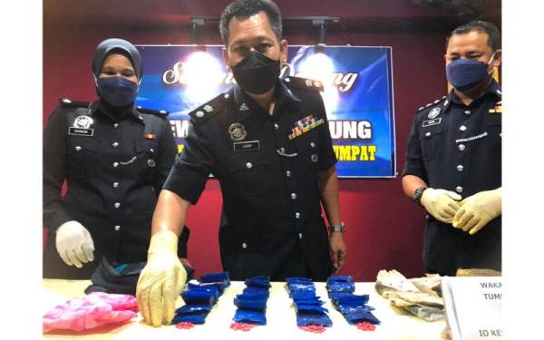 Ketua Polis Daerah Tumpat, Superintendan Mohd Azmir Damiri (tengah) dan pegawai-pegawai menunjukkan dadah berjumlah 9,000 biji dianggarkan bernilai RM90,000.