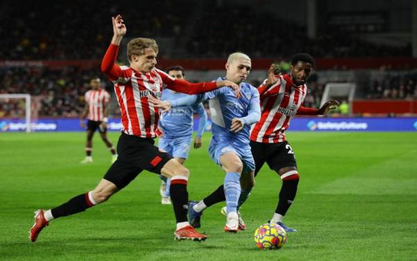 Pemain City, Phil Foden (tengah) bergelut untuk melepasi kawalan benteng pertahanan, Brentford. - Foto Reuters