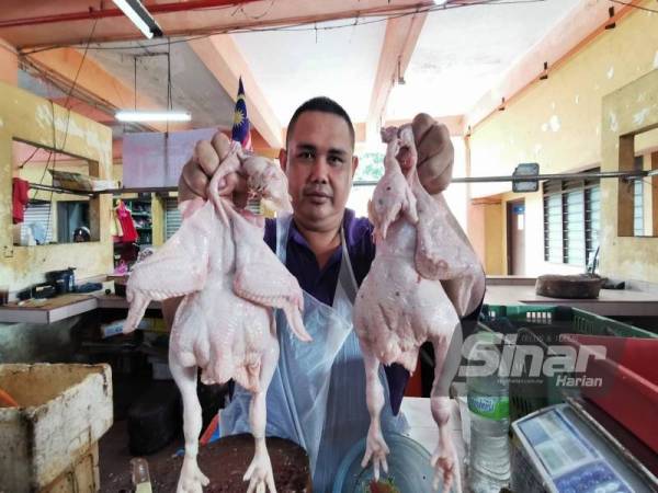 Mohd Hilmi menunjukkan baki dua ekor ayam yang sudah ditempah pelanggan di gerainya di Pasar Bukit Besar.