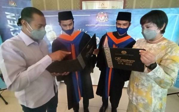 Muhammad Aidil Mohamad Fazli, 21, (dua dari kanan) dan Muhammad Fitri Mohamad Fazil, 21, (dua dari kiri) berkongsi kegembiraan bersama ibu bapanya pada majlis berkenaan.