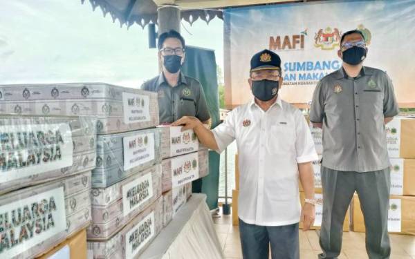 Ahmad (tengah) menunjukkan sebahagian sumbangan bekalan makanan haiwan kepada Zoo Melaka di Ayer Keroh pada Jumaat.