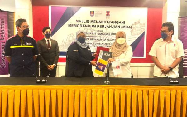 Dr Roziah (tiga dari kiri) dan Dr Nik Maheran (dua dari kanan) bertukar MoA ditandatangani antara UiTM dan UMK di sebuah hotel di Kota Bharu pada Ahad.