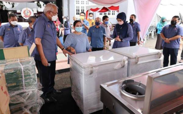 Mahdzir (tiga dari kiri) melihat peralatan yang diterima oleh peserta program Warung Desa@KPLB di Kuala Nerang pada Ahad.