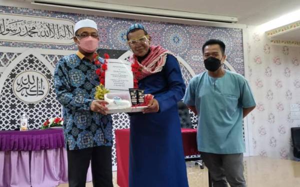 Mohd Khariri (tengah) menyampaikan cederahati kepada Mohd Kazim yang turut membantu komuniti transgender untuk mendalami agama Islam.