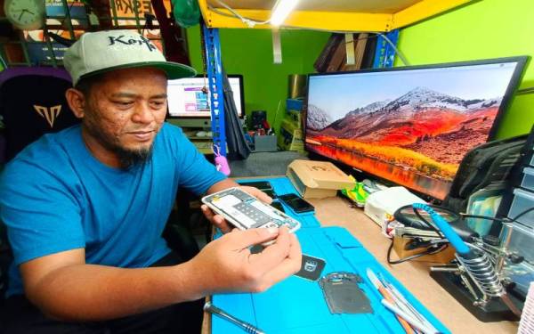 Mohd Idris menawarkan khidmat membaiki telefon bimbit secara percuma di rumahnya di Kampung Kubang Bunut, Pasir Mas.