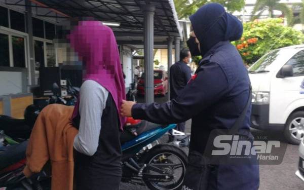 Remaja perempuan (kiri) didakwa di Mahkamah Majistret Kemaman pada Selasa atas pertuduhan membunuh bayi yang baru dilahirkannya.