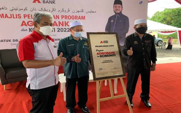 Nik Muhammad Zawawi (kanan) selepas merasmikan logo bagi Program Agrobank dan Komuniti di Cherang Rotan, Pasir Puteh pada Selasa.