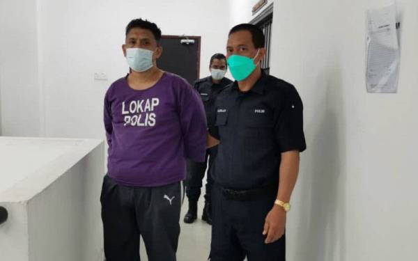 Tertuduh (kiri) dikawal polis keluar dari bilik Mahkamah Sesyen Kota Bharu selepas mengaku tidak bersalah atas tuduhan memiliki pistol, peluru dan parang. - FOTO SINAR HARIAN