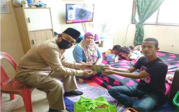 Tosrin menyampaikan sumbangan MAINJ kepada pasangan suami isteri bisu dan pekak di rumah mereka di Taman Setia Indah, Johor Bahru, pada Rabu.