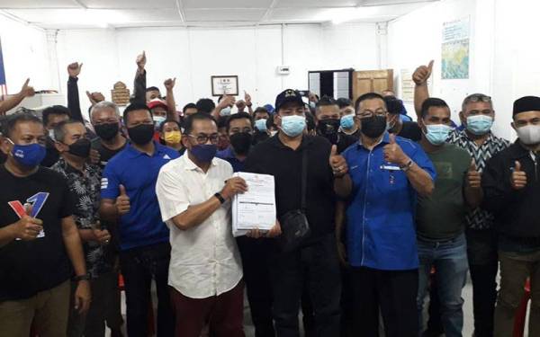 Mohamed Khaled (depan) menerima borang kemasukan UMNO daripada bekas Ketua Bersatu Cawangan Tasek 64, Mohamad Noh Hamzah di Bilik Gerakan Jalan Tasek 21, Bandar Seri Alam, Pasir Gudang, pada malam Jumaat.