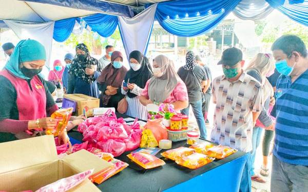 Orang ramai beratur untuk membeli manyak masak peket di PJKM Durian Tunggal, di sini, pada Sabtu.