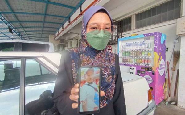 Rushila menunjukkan gambar Allahyarham suaminya, Mohamad Nor Safuan ketika ditemui di Jabatan Forensik, Hospital Tuanku Jaafar, Seremban pada Ahad.