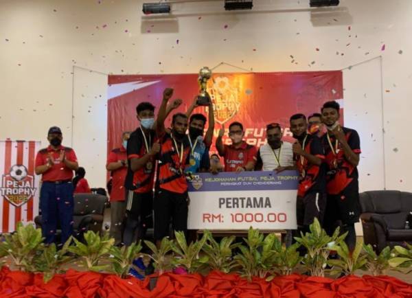 Ahmad Faizal (tengah) bersama pasukan yang menjuarai Kejohanan Bola Sepak Peja Trophy 2022 Peringkat DUN Chenderiang di Kompleks Sukan Batang Padang di sini pada Ahad.
