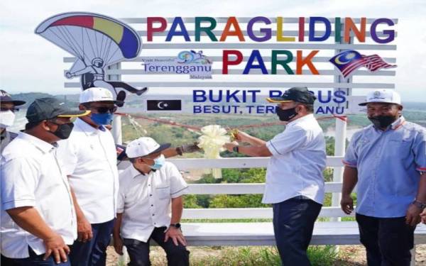 Tengku Farok Hussin (dua, kanan) memotong riben ketika mengadakan lawatan ke Bukit Bubus, Tembila di sini.