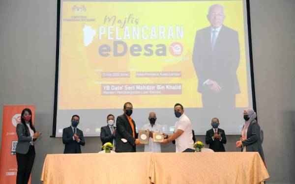 Mahdzir (tengah) menyaksikan pertukaran dokumen persefahaman pada Majlis Pelancaran platform e-Desa di Kuala Lumpur pada Isnin.