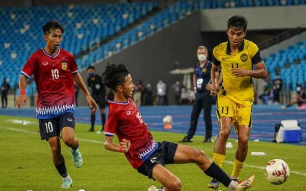 Penyerang negara, Nur Azfar Fikri Azhar diasak pertahanan Laos dalam aksi kedua Kumpulan B Kejuaraan AFF 2022 di Stadium Morodok Techo pada Isnin. - Foto: FB FAM