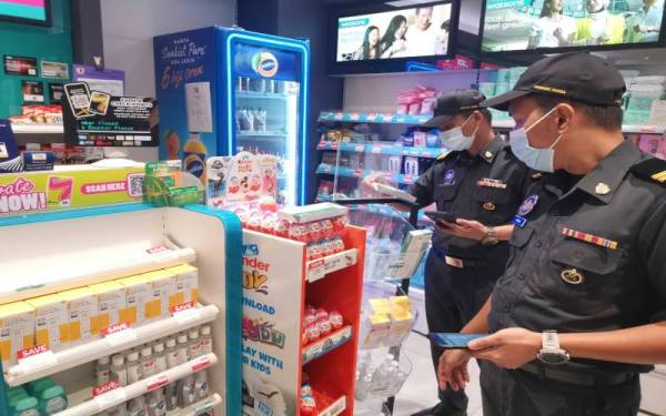 Pegawai KPDNHEP memeriksa bekalan paracetamol di ruang pameran di sebuah premis