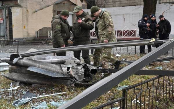 Pihak berkuasa Ukraine memeriksa serpihan peluru selepas kejadian letupan menggegar Kiev sejurus Putin (gambar kecil) mengumumkan ‘operasi khas’ pada Khamis. - Foto: AFP