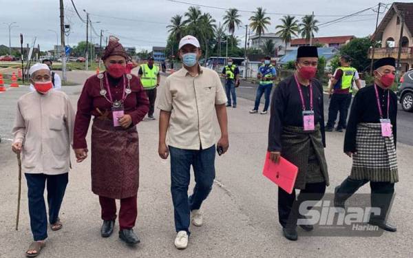 Mohamad Fakrulradzi (dua dari kiri) hadir di PPC bersama bapanya Mahmud (kiri) bagi penamaan calon di DUN Endau pada Sabtu.