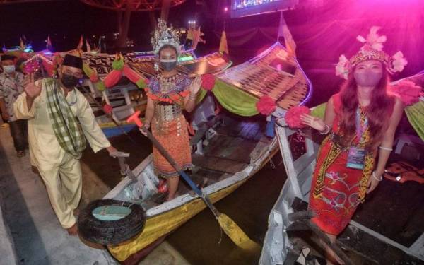 Dua penari berpakaian tradisional suku kaum Sarawak menaiki perahu penambang pada perasmian Citrawarna Keluarga Malaysia 2022 di Tebingan Sungai Kuching, malam Sabtu. - Foto Bernama