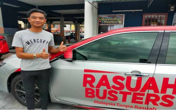 Muhammad Nazrul Ikmal bergambar dengan kenderaan pasukan Rasuah Busters ketika pasukan itu bertemu penduduk di Bandar Tangkak.