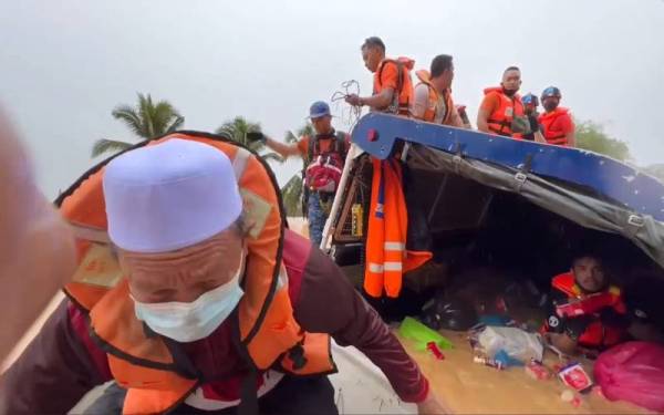 Maliaman (kiri) ketika diselamatkan dalam insiden trak bantuan bencana banjir yang terbalik dekat Kampung Bukit Biah, di Hulu Terengganu.