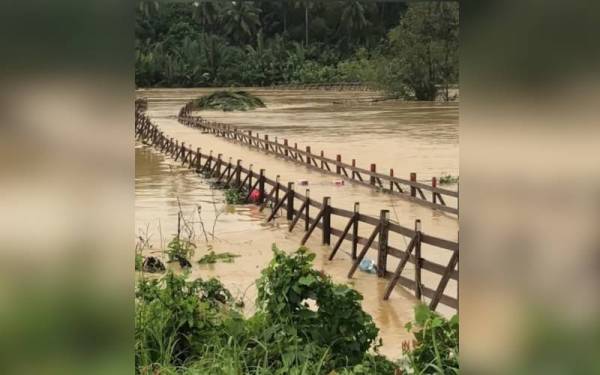 Jambatan kayu Kampung Pulau Sekati dihanyutkan arus yang tular di media sosial pada Ahad. - Foto Sumber media sosial