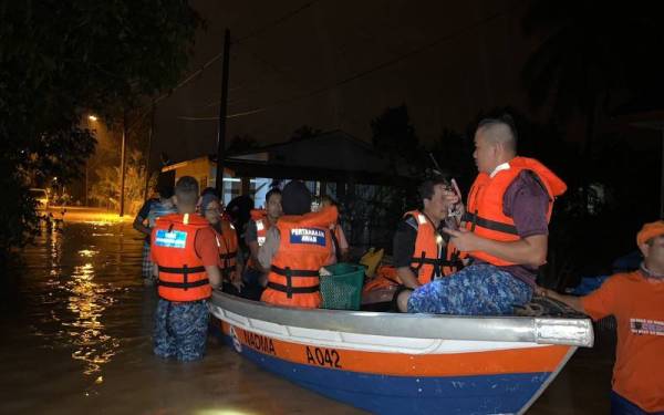 Pasukan penyelamat sedang membantu memindahkan mangsa yang terjejas banjir.