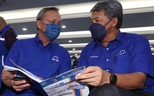 Mohamad (kanan) melihat manifesto BN Johor bersama Hasni pada majlis berkenaan.