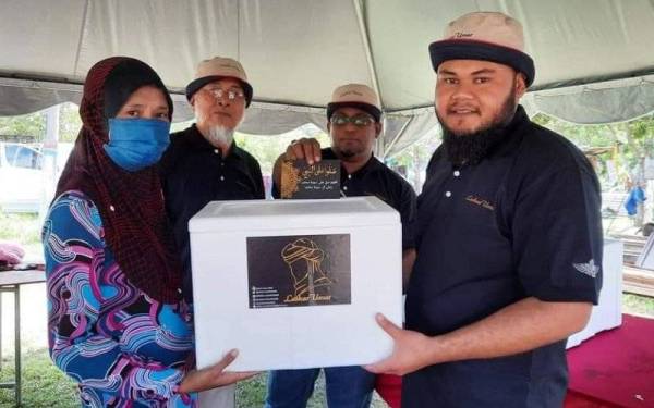 Mohammad Fakrulradzi (kanan) ketika menyampaikan bantuan kepada penduduk di kawasan Endau baru-baru ini. - Foto Mohammad Fakrulradzi Mahmud